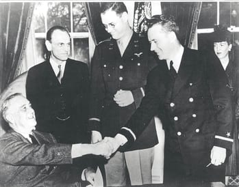 President Franklin Delano Roosevelt, seated left, presents the first two Air Medals ever awarded by the U.S. to CAP subchasers Maj. Hugh Sharp Jr., center, and 1st Lt. Eddie Edwards, second from right, for the rescue of 1st Lt. Henry Cross. Looking on is James Landis, wartime chief of the Office of Civilian Defense. 