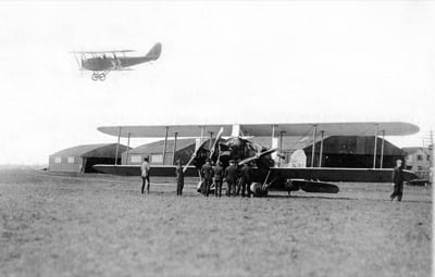 This Jenny, seen landing at Mineola Airport in Long Island, was flown by Richard Depew, who finished 22nd in the speed race and fifth in the handicap race. Seen on the ground is a new three-engined Eagle intended by Curtiss as a post-war airliner.