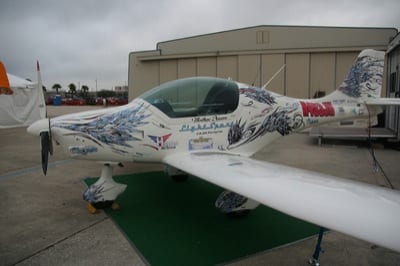 side 2 The Peregrine starts out all white. Customers can chose a graphics package for the finish. This particular airplane was covered with advertisements for the sponsors of the Hansen/Scharle cross-country trip and what appeared to be feathers. "There's a story behind that," Hansen laughed. "The artist, Rob Winchester at TheInHouse, said that he'd donate the design if Matt allowed him to have free reign. At first we were scratching our heads when we saw the feathers, but it kind of grows on you. Rob said 'it's different, but anybody can do a stripe'. The design has a lot of whirls and feathers on it. It looks like what you would imagine a bird would look like if it over-sped itself."