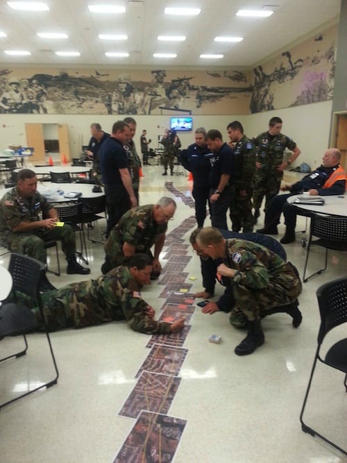 Members of Civil Air Patrol’s Kansas and Oklahoma wings review a mosaic of images pasted together of the Moore tornado’s track to help formulate a plan of attack for ground sorties in support of FEMA.